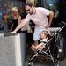 Alek Dragovic, of Ann Arbor, checks out the artwork of artist Melvin McGee as his daughter Mila, 1, looks up from her stroller on E. Liberty St. during the Guild's Ann Arbor Summer Art Fair on Thursday, July 18, 2013. Melanie Maxwell | AnnArbor.com